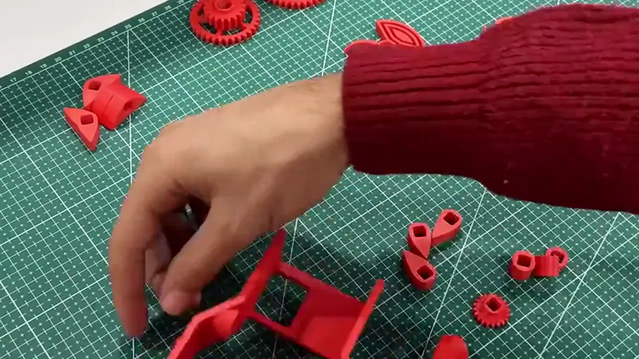 CEZERİ ROBOTECH atölyesinde 3D yazıcıyla basılan eklemli el projesinin parçaları ve öğrencilere demonte verilen setin montajı