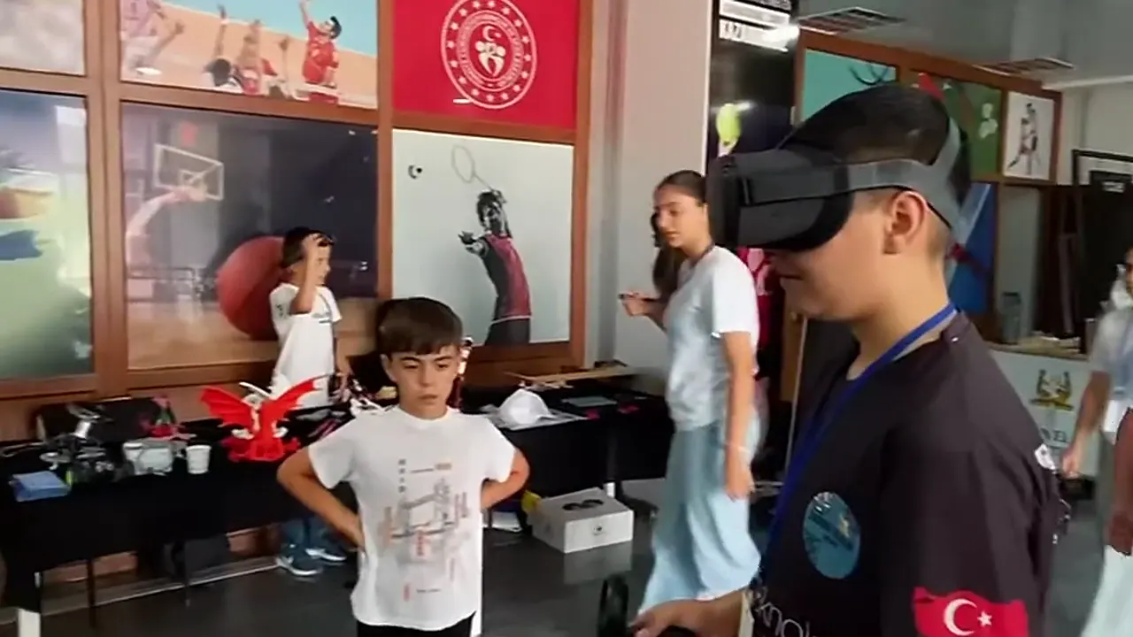 CEZERİ ROBOTECH'in YEDİİKİ Robot Yarışması'ndaki standında VR gözlük deneyen ve robotları inceleyen ziyaretçi çocuklar